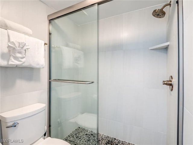 full bath with a stall shower, tile walls, and toilet