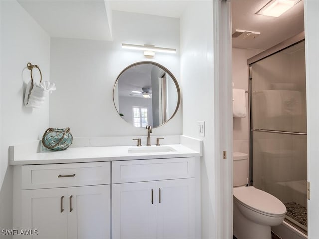 full bathroom featuring visible vents, toilet, a stall shower, ceiling fan, and vanity