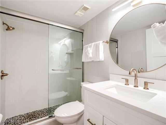 full bath featuring toilet, vanity, a shower stall, and visible vents