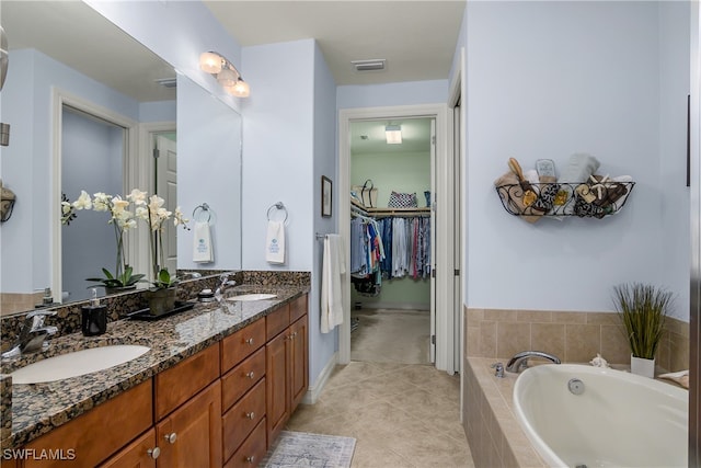 bathroom featuring vanity, tiled bath, and tile patterned floors