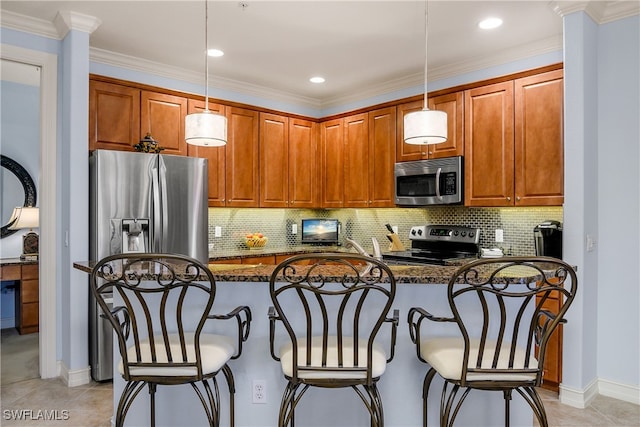 kitchen featuring dark stone counters, a breakfast bar, hanging light fixtures, and stainless steel appliances