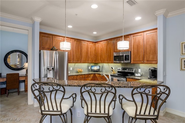 kitchen with stainless steel appliances, kitchen peninsula, dark stone countertops, pendant lighting, and a kitchen bar