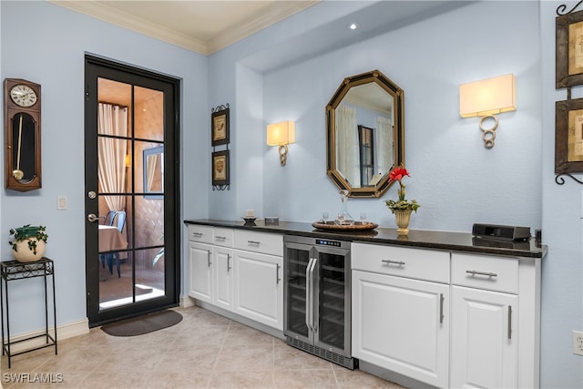 bar with wine cooler, white cabinetry, crown molding, and light tile patterned floors