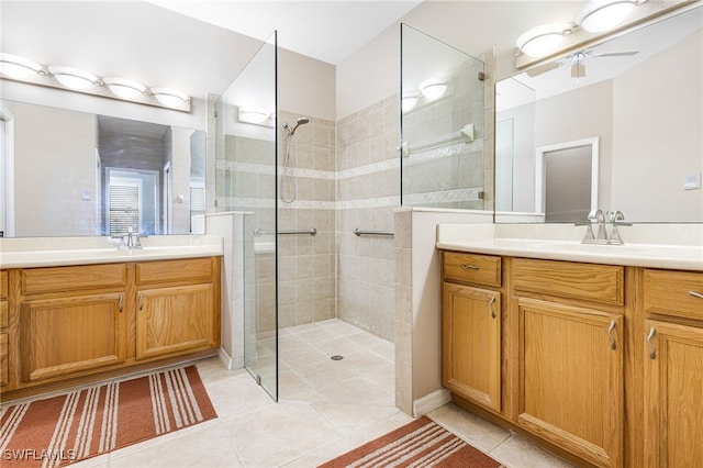 bathroom featuring tiled shower, vanity, ceiling fan, and tile patterned flooring