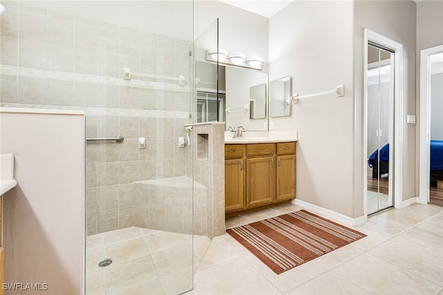 bathroom featuring tiled shower, vanity, and tile patterned floors