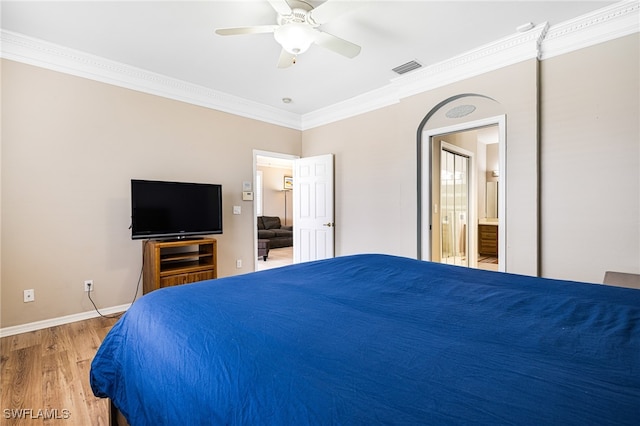 bedroom featuring ensuite bath, ceiling fan, ornamental molding, and hardwood / wood-style flooring