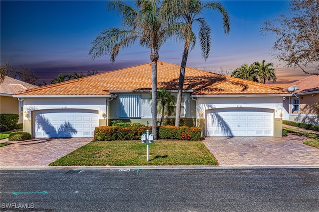 view of front of home with a yard and a garage