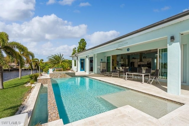 view of pool with an in ground hot tub, a water view, and a patio area