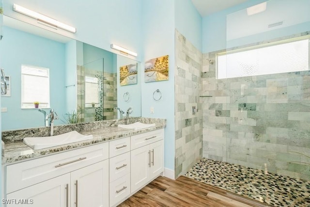 bathroom featuring vanity, wood-type flooring, and tiled shower