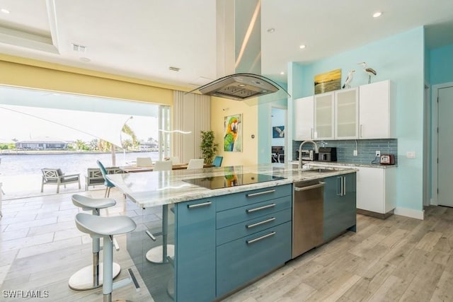 kitchen with island range hood, sink, white cabinetry, and a kitchen island with sink