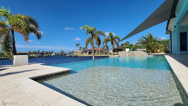 view of pool featuring a patio area, pool water feature, and a water view