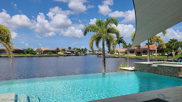 view of pool featuring an in ground hot tub and a water view