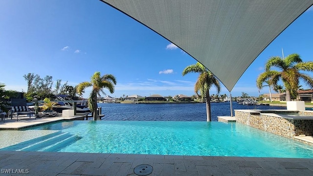 view of swimming pool featuring an in ground hot tub, a water view, and a patio