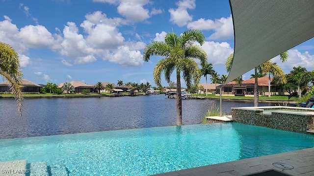 view of swimming pool featuring a water view and an in ground hot tub