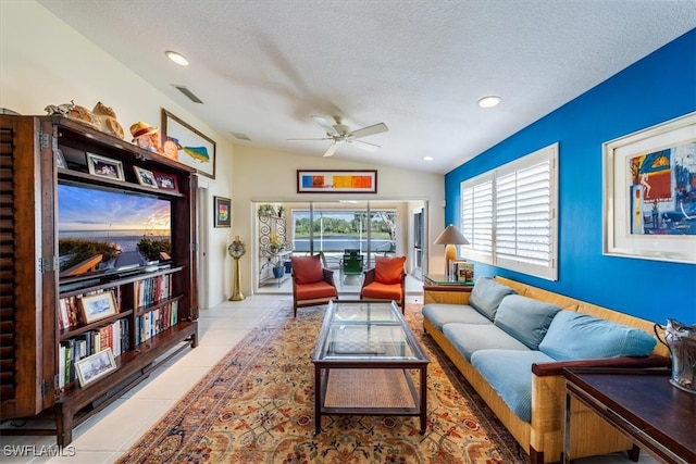 tiled living room with a textured ceiling, ceiling fan, and lofted ceiling