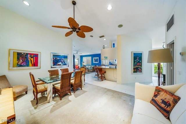 dining space with ceiling fan and light colored carpet