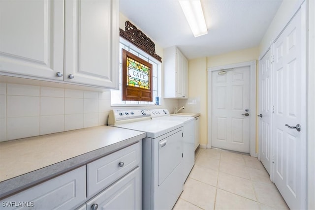 laundry area featuring cabinets, light tile patterned flooring, and washing machine and clothes dryer