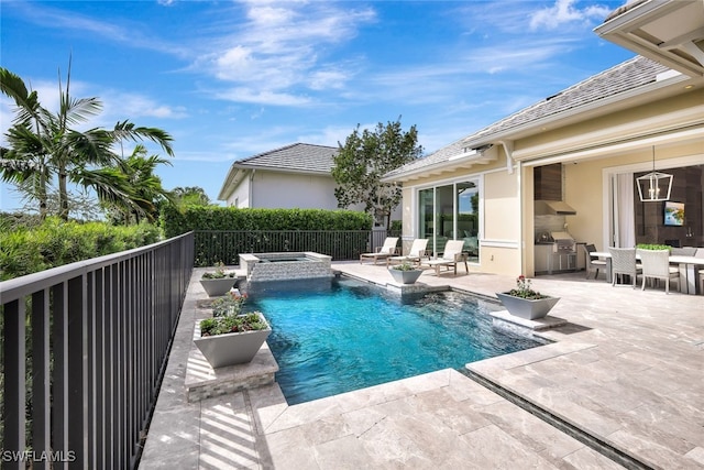 view of pool featuring an in ground hot tub, exterior kitchen, and a patio