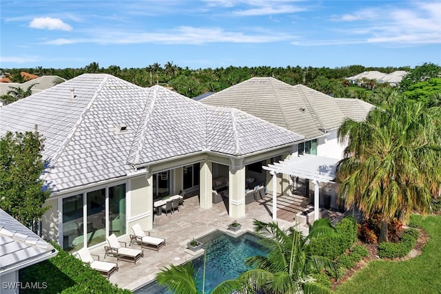 rear view of property featuring a pergola, an outdoor living space, and a patio