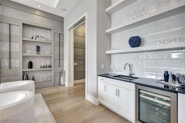 bar with sink, wine cooler, light hardwood / wood-style flooring, built in features, and white cabinetry