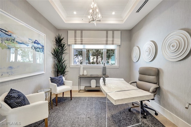 office space featuring a chandelier and a tray ceiling