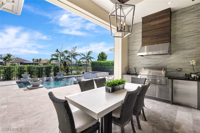 view of patio with grilling area, sink, pool water feature, a swimming pool with hot tub, and exterior kitchen