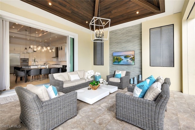 living room with a raised ceiling, wooden ceiling, and an inviting chandelier