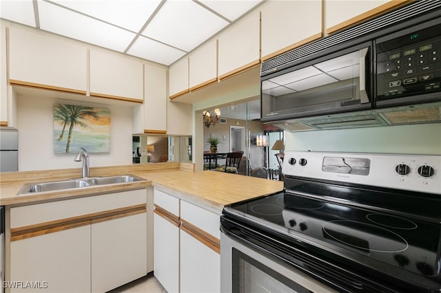 kitchen with white cabinets, black appliances, and sink