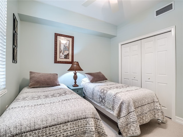 carpeted bedroom featuring ceiling fan and a closet