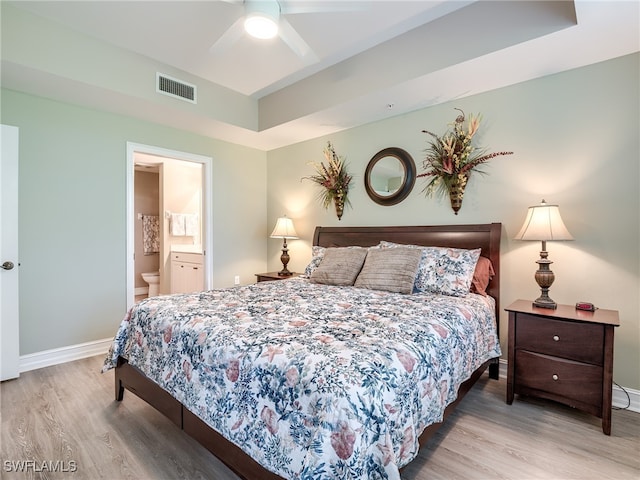 bedroom featuring ensuite bathroom, light hardwood / wood-style flooring, and ceiling fan