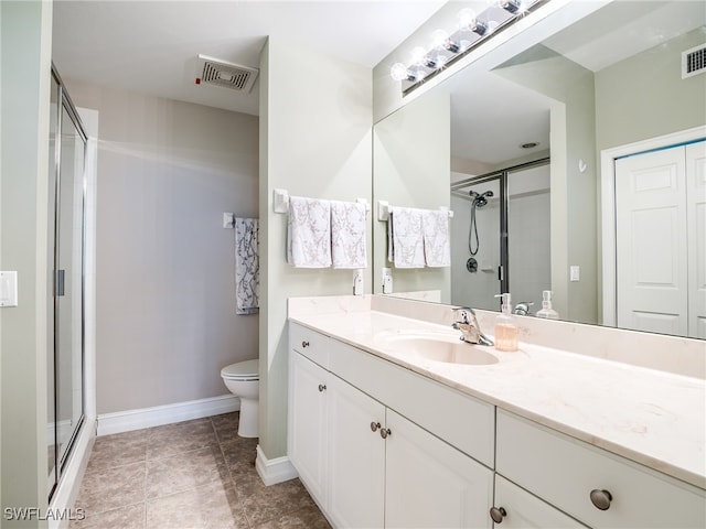 bathroom with a shower with door, vanity, and toilet