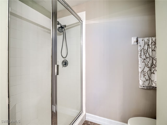 bathroom with toilet and a shower with shower door