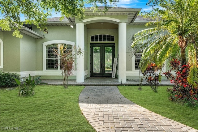 property entrance with a yard and french doors