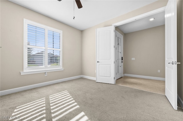 empty room featuring light colored carpet and ceiling fan