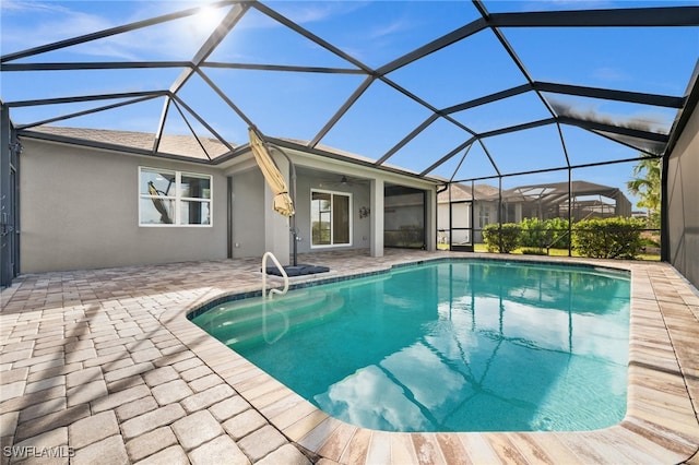 view of pool with ceiling fan, a lanai, and a patio area