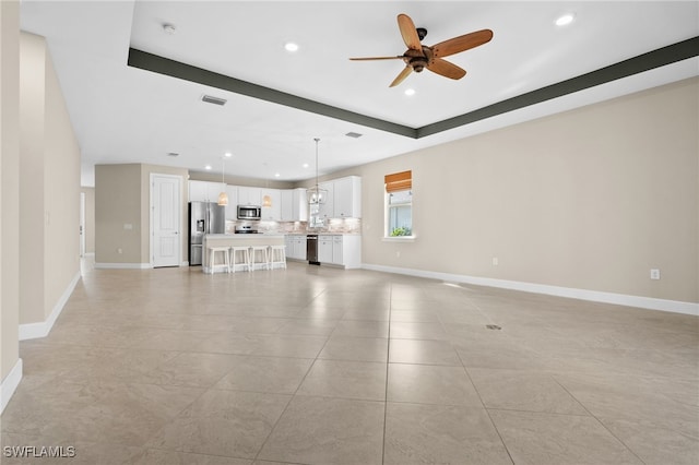 unfurnished living room with light tile patterned floors and ceiling fan