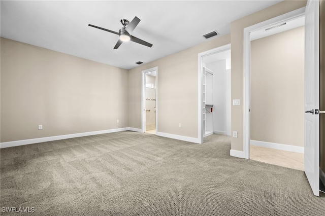 unfurnished bedroom featuring ceiling fan, connected bathroom, a spacious closet, and carpet floors