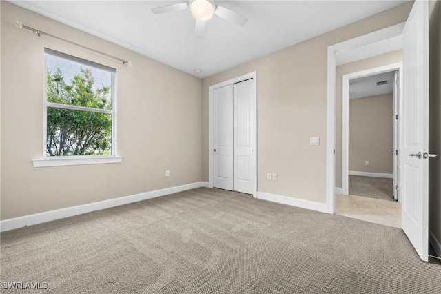 unfurnished bedroom with a closet, carpet, and ceiling fan