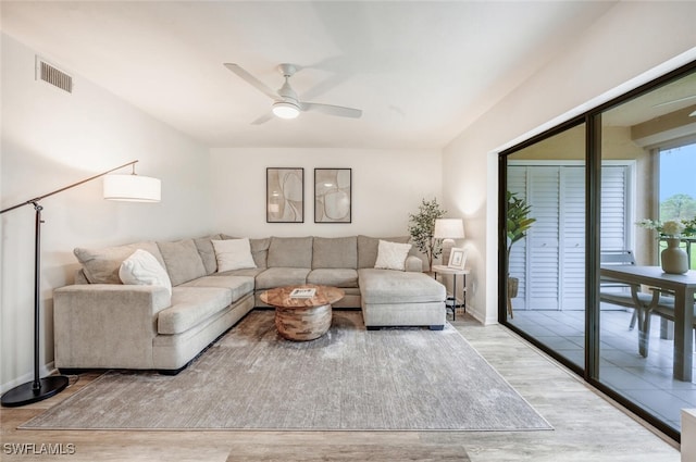 living room featuring ceiling fan and light hardwood / wood-style floors