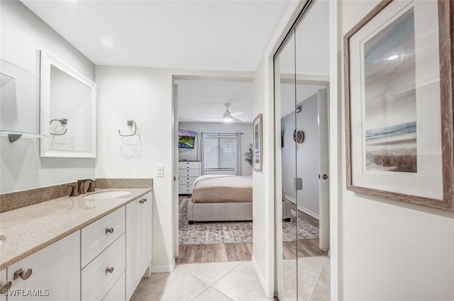 bathroom with hardwood / wood-style floors, ceiling fan, and vanity