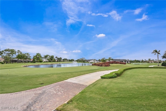 view of property's community with a water view and a lawn