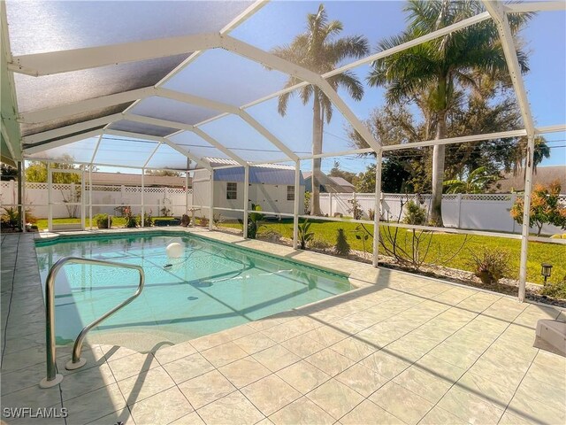 view of pool featuring a patio, a yard, and glass enclosure