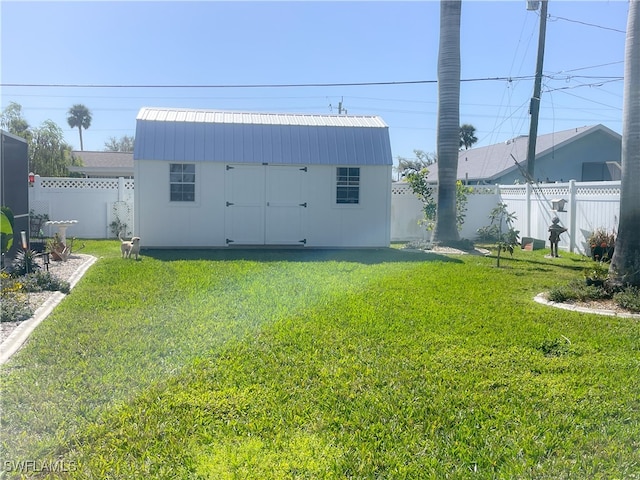 back of house featuring a shed and a lawn