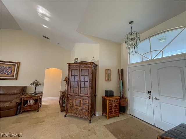 foyer with an inviting chandelier and high vaulted ceiling