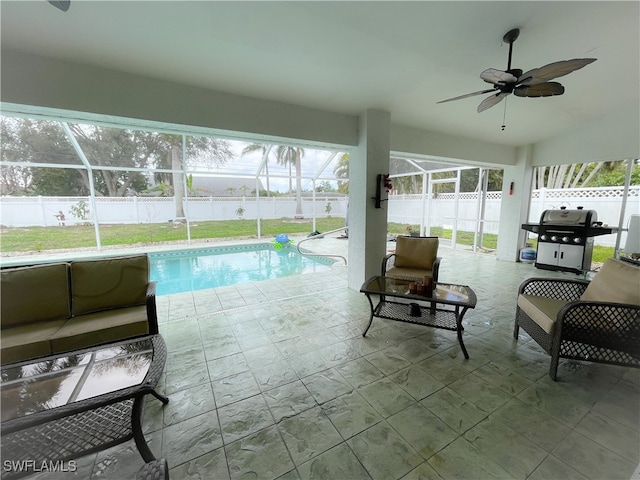 view of swimming pool with a grill, a patio area, ceiling fan, and glass enclosure