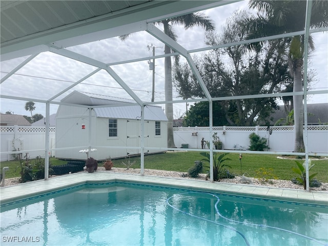 view of swimming pool featuring a lanai, a shed, and a lawn