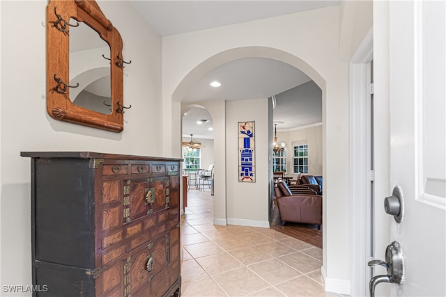 hallway with light tile patterned floors and ornamental molding