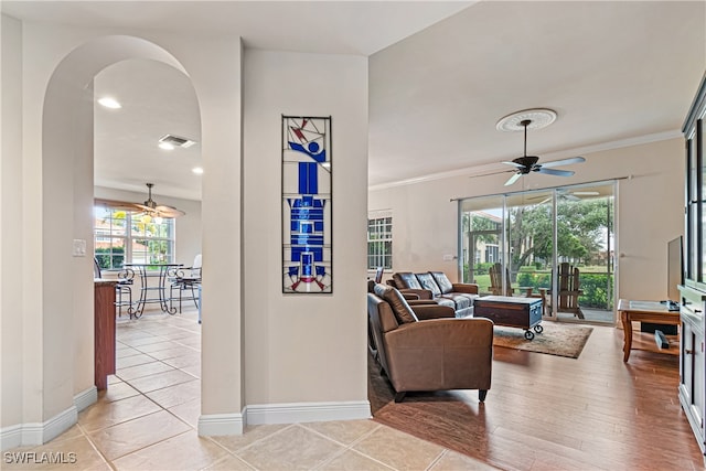 living room featuring ceiling fan, plenty of natural light, light hardwood / wood-style flooring, and crown molding