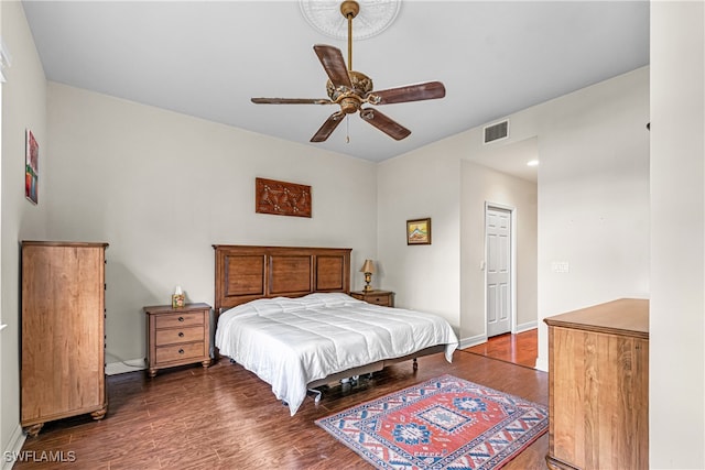 bedroom with dark wood-type flooring, ceiling fan, and a closet