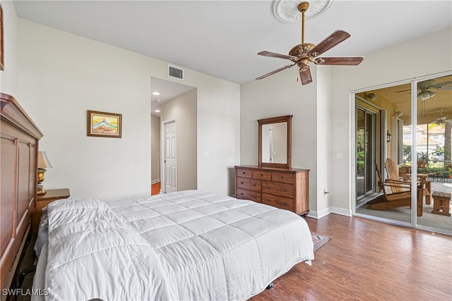 bedroom with access to outside, hardwood / wood-style floors, and ceiling fan